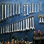 Neatly arranged wrenches and tools on a workshop wall, ideal for mechanics.